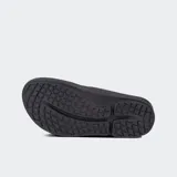 Sandalias tipo ojota de color negro, con tira ancha y logo de la marca en el lateral. Presentan una suela gruesa y ergonómica con soporte de arco.