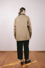 Campera color beige confeccionada en tela de algodón con cuello de pana marrón.
