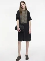 Vestido túnica camisera color negro con botones en la parte delantera, cuello mao y detalle de bordado en el pecho y mangas. Presenta tajos verticales laterales.