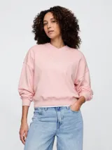 Buzo deportivo color rosa con cuello en V y logo de la marca bordado en el frente.