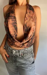 Top marrón con estampado animal print, escote halter y espalda descubierta.