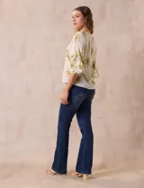 Blusa de gasa color crema con estampado de flores amarillas, de la marca Sioni. Tiene mangas 3/4 con volados y cuello redondo.