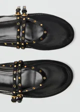 Zapato tipo ballerina color negro, de tejido de malla con detalles troquelados y doble tira con cierre de hebilla.