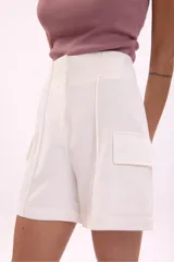 Short blanco de corte recto con bolsillos frontales y detalles de costura.