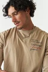 Remera manga larga color beige con cuello redondo y estampado frontal con la frase 'Lost Minds Unlimited Freedom'.