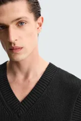 Chaleco negro de punto con cuello en V y sisas.