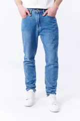 Pantalón jean de corte slim color azul medio, con bolsillos delanteros y traseros.