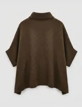 Capa tejida color fucsia, con cuello alto abotonado y mangas cortas estilo japonesa. Tejido de punto grueso.