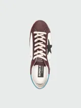Championes Golden Goose modelo Super Star, color bordó y blanco con estrella negra en el lateral.