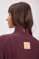 Sweater de punto color borgoña con cuello alto y diseño trenzado.