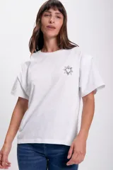 Remera blanca de algodón con cuello redondo y mangas cortas. Presenta un pequeño estampado de un corazón con rayos en el lado izquierdo del pecho.