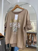 Remera negra de algodón con estampado de animal print en dorado, plateado y gris.