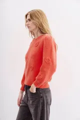 Sweater color coral de lana y mohair con calce holgado y mangas largas. Presenta frunces en hombros, escote, puños y ruedo en rib. Tiene aplicación de flores tejidas con detalle de strass.