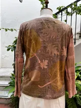 Remera de manga larga con escote en V, confeccionada en jersey de algodón peinado. Tiene detalle de morley en bajo mangas y tajos a los lados. Presenta estampa botánica.