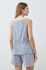 Chaleco con estampado a rayas verticales azules y blancas, con breteles finos y cierre frontal con botones. Presenta dos bolsillos frontales a la altura del pecho.