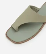Sandalia plana tipo mule color crema, con puntera cuadrada, tira ancha en la parte superior y detalle de dedo.