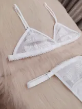 Conjunto de lencería blanco de microtul suave y elastizado con detalles de encaje. Incluye corpiño triangular y tanga regulable de elástico ancho con entrepierna de algodón.