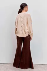 Jeans acampanados de tiro alto, color marrón oscuro, con costuras decorativas en contraste.