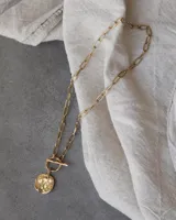 Collar plateado con cadena de eslabones y dije circular texturizado.