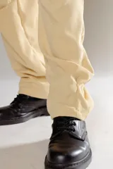 Pantalón de jogging color amarillo de tela corderoy liviano, con bolsillos laterales, cintura elástica con cordón y ojalillos personalizados.