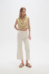 Pantalón jean blanco, recto y de calce alto con terminación desflecada.