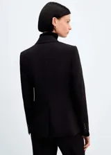 Blazer negro entallado con cuello de pico y solapa con muesca, manga larga, hombros estructurados, dos bolsillos de ribete delanteros, pinzas, abertura posterior y forro interior.