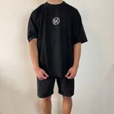 Remera negra de corte oversize y mangas cortas, con estampa en la espalda de una fotografía en blanco y negro de una persona fumando.