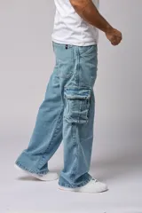 Pantalón jean celeste de corte amplio, estilo cargo, con bolsillos laterales con fuelle y solapa.