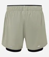 Bermuda deportiva color verde claro con short de compresión interno negro, cintura elástica con cordón ajustable y detalle reflectante trasero.
