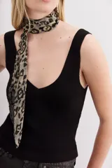 Musculosa blanca tejida en hilado de algodón, con escote en V pronunciado y calce al cuerpo.