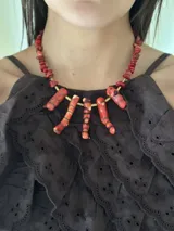 Collar corto con cuentas de coral rojo, bastones de bronce y cadena de acero quirúrgico con cierre de gancho ajustable.