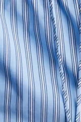 Short celeste con rayas verticales blancas y azules, cintura elástica con cordón ajustable y bolsillos laterales.