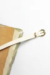 Cinturón marrón con hebilla dorada.