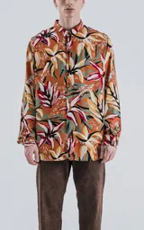 Camisa de manga larga con estampado de flores y hojas en tonos naranja, blanco, rojo, verde y negro.