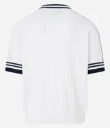 Camisa polo de punto color blanco con rayas azul marino en cuello y mangas. Tiene bordados localizados y lettering.