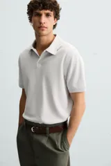 Polo de piqué color crudo, corte regular fit, cuello solapa con cierre de botonadura y mangas cortas.