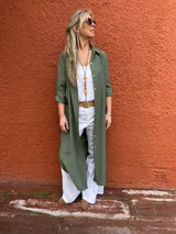 Sobrecamisa larga verde militar de viscosa con cuello camisero, cierre frontal con botones y mangas largas con puños abotonados. Presenta tajos laterales.