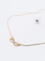 Conjunto de collar dorado con dije de infinito con strass y aros dorados con strass.