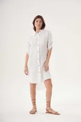 Vestido camisero blanco de lino, con cuello clásico, cierre frontal con botones y mangas 3/4 con trabillas.