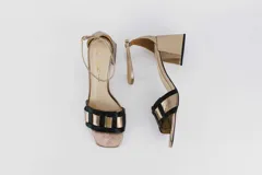 Sandalias plateadas de cuero con tiras entretejidas en el empeine, pulsera al tobillo con hebilla y tacón cuadrado. Marca Fiore.