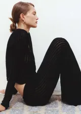 Pantalón negro de tejido de punto calado con cintura elástica y corte recto.