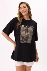 Remera color beige de corte amplio con mangas cortas y cuello redondo. Estampado frontal con la palabra "Monaco" en la parte superior y una fotografía en blanco y negro con la frase "Mont Carlo" en la parte inferior.