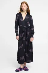 Vestido largo estilo camisero confeccionado en seda viscosa color negro con estampado de tigres en color rosa. Tiene cuello camisero, mangas largas, corte cruzado y lazo en la cintura.