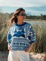 Remera de algodón blanca con estampado floral en tonos azules, cuello redondo y mangas cortas amplias.