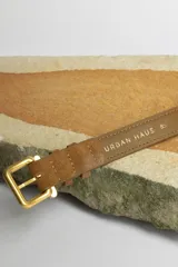 Cinturón marrón de gamuza con hebilla dorada.