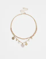 Collar corto dorado de doble cadena, una de eslabones y otra de cuentas facetadas color durazno. Incluye dijes colgantes de estrella, luna, corazón, ojo turco y medallones.