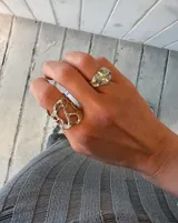 Anillo dorado con diseño abstracto con aberturas.