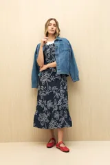 Vestido midi blanco con bordado floral calado, corte evasé y breteles finos.