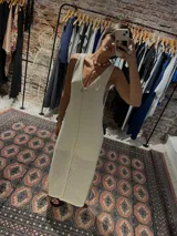 Vestido midi tejido color crema, con escote en V y calado en la parte inferior.