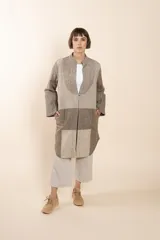 Camisa larga color beige con cuello mao, manga larga con tajo y botón. Diseño con bloques de tela con textura.